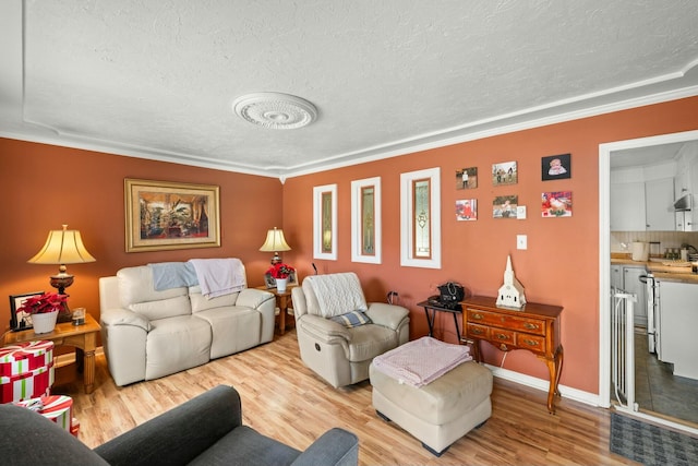 living room featuring a textured ceiling, light wood-type flooring, and crown molding