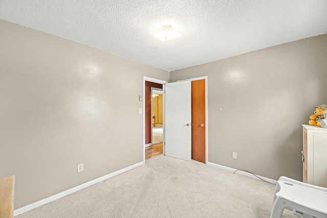 unfurnished bedroom featuring a textured ceiling and light colored carpet