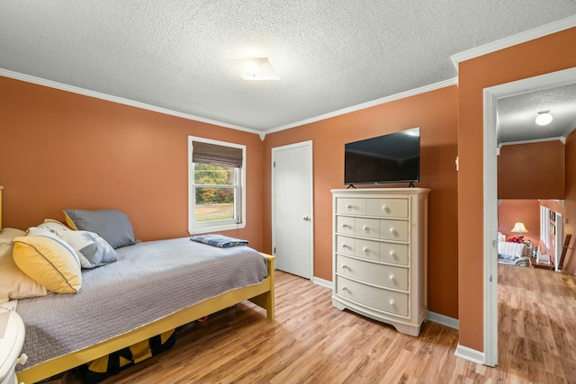 bedroom with a textured ceiling, crown molding, and light hardwood / wood-style flooring