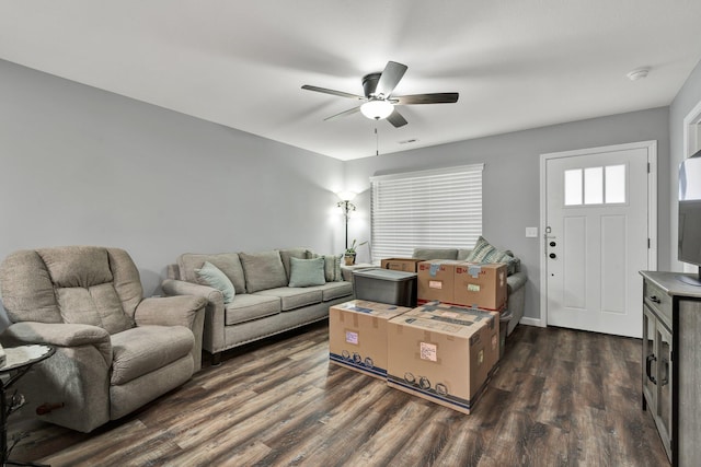 living room featuring dark wood-type flooring and ceiling fan