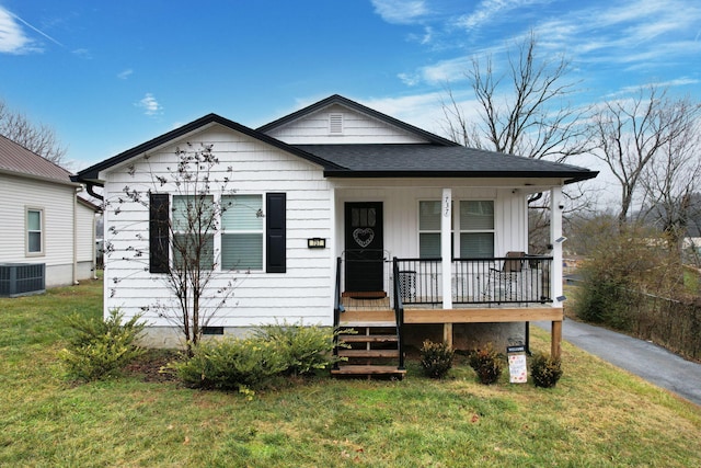 bungalow with cooling unit, a porch, and a front yard