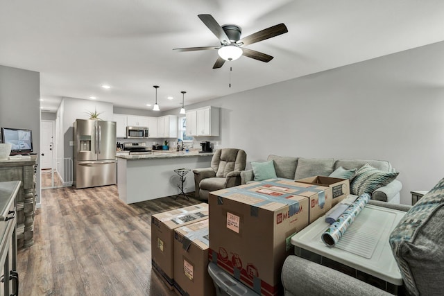 living room with ceiling fan, wood-type flooring, and sink