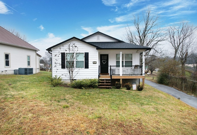 view of front of property featuring cooling unit, a front yard, and covered porch