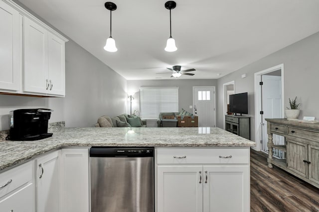 kitchen featuring light stone counters, dark wood-type flooring, stainless steel dishwasher, and white cabinets