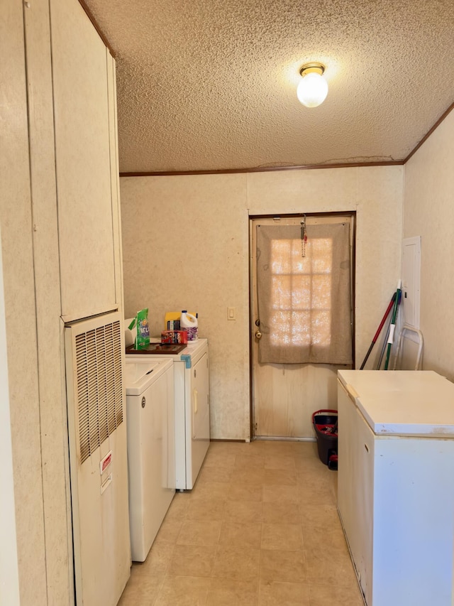 laundry room with crown molding, washer and dryer, and a textured ceiling