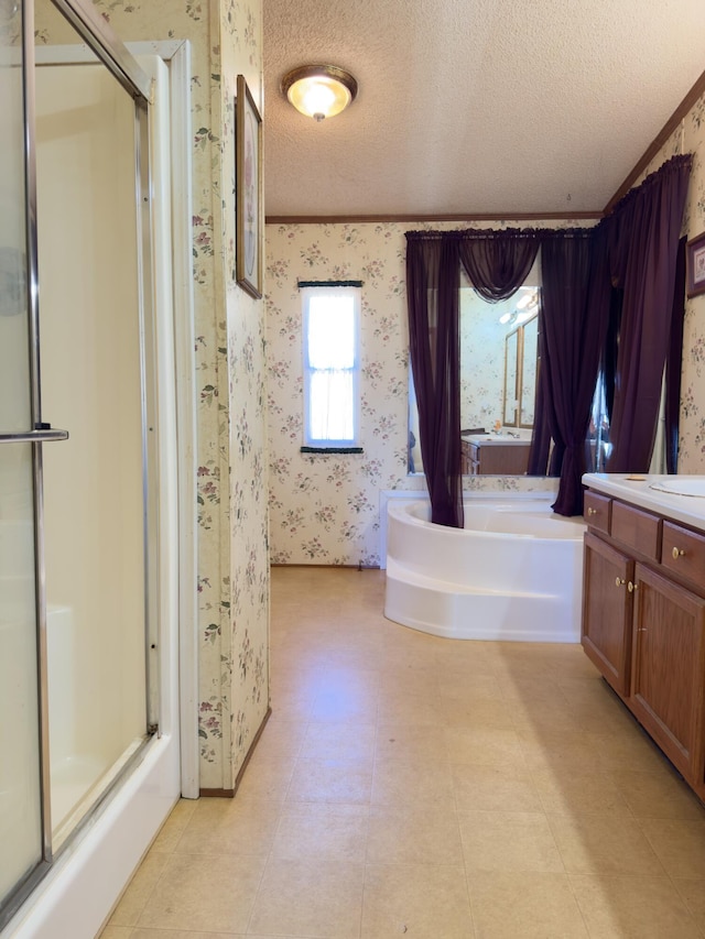 bathroom with vanity, separate shower and tub, and a textured ceiling