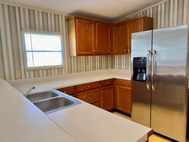 kitchen with sink, a textured ceiling, and stainless steel refrigerator with ice dispenser