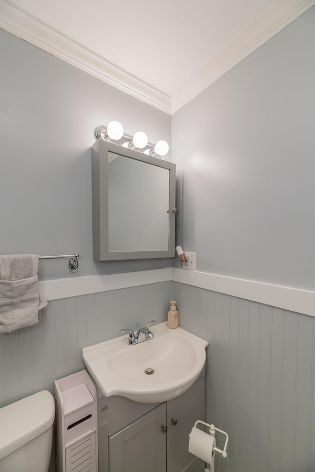 bathroom featuring vanity, crown molding, and toilet