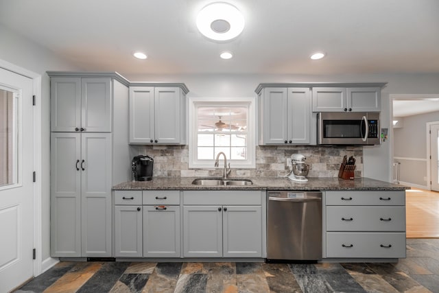 kitchen with tasteful backsplash, sink, stainless steel appliances, and gray cabinetry