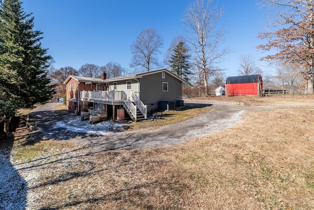 view of home's exterior featuring a storage unit and a deck