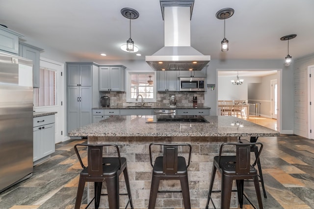 kitchen featuring sink, hanging light fixtures, backsplash, stainless steel appliances, and island exhaust hood