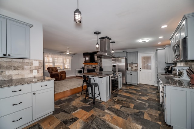 kitchen featuring hanging light fixtures, backsplash, stainless steel appliances, and a kitchen island