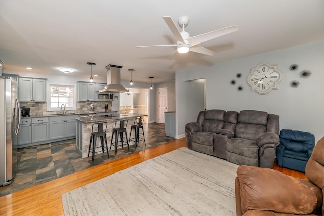 living room with sink, dark wood-type flooring, and ceiling fan