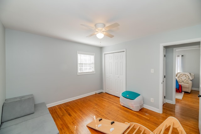 living area featuring hardwood / wood-style flooring and ceiling fan