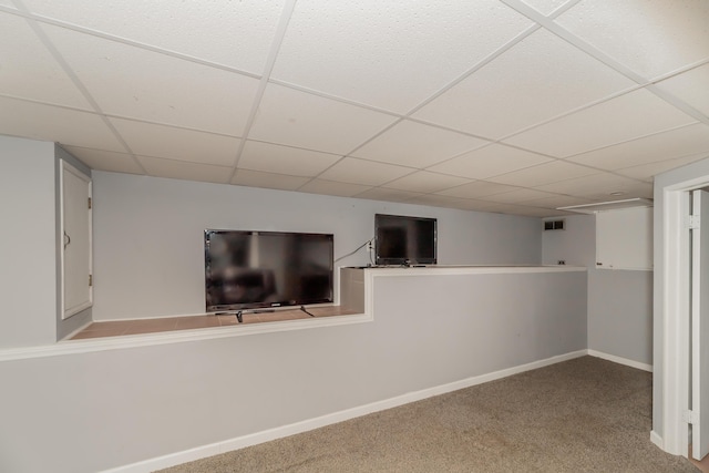 basement featuring light carpet and a paneled ceiling