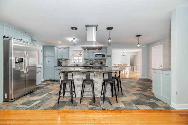 kitchen featuring sink, stainless steel appliances, island range hood, decorative backsplash, and decorative light fixtures