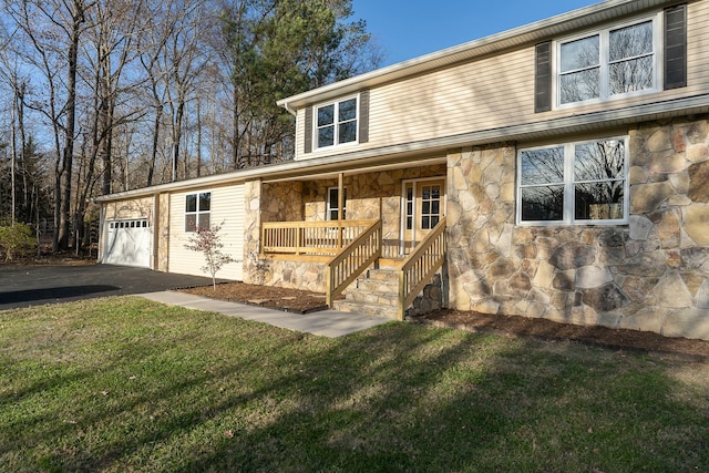 view of front of home featuring a porch, a garage, and a front yard