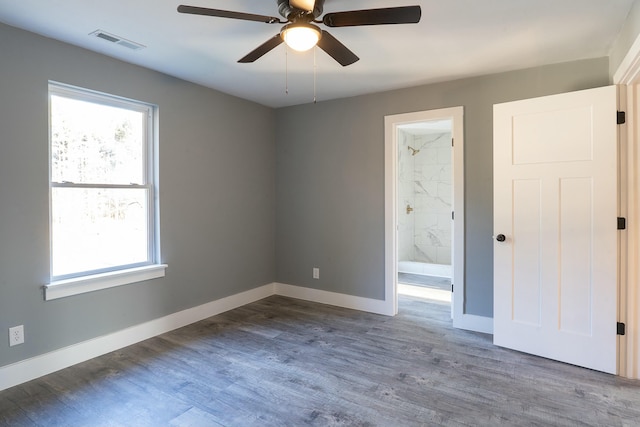 spare room featuring plenty of natural light, ceiling fan, and wood-type flooring