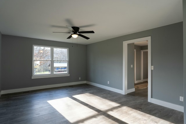 spare room with ceiling fan and dark wood-type flooring