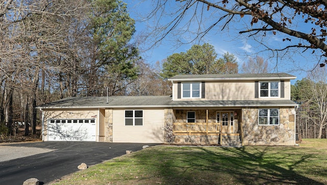 view of front of home featuring a front lawn, a porch, and a garage