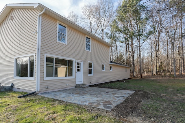 back of property featuring a lawn and a patio