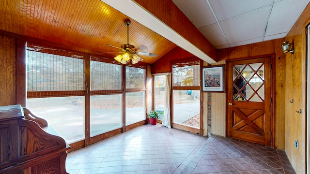 unfurnished sunroom featuring ceiling fan, plenty of natural light, and lofted ceiling with beams