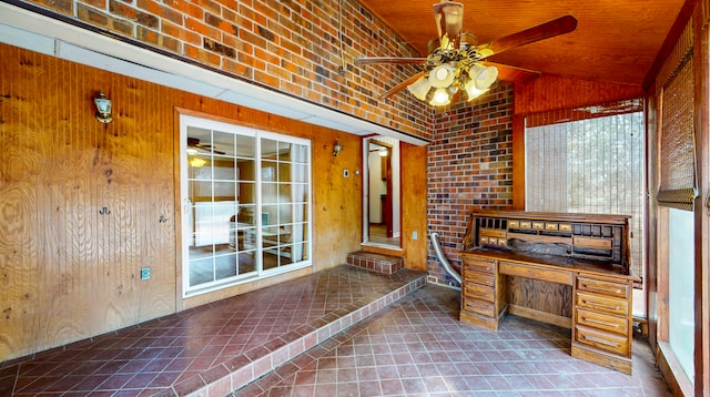 unfurnished office featuring ceiling fan, brick wall, vaulted ceiling, wooden walls, and wood ceiling