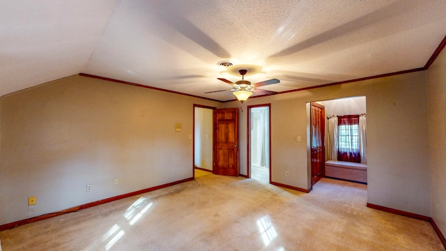 unfurnished bedroom with lofted ceiling, light carpet, crown molding, ceiling fan, and a textured ceiling