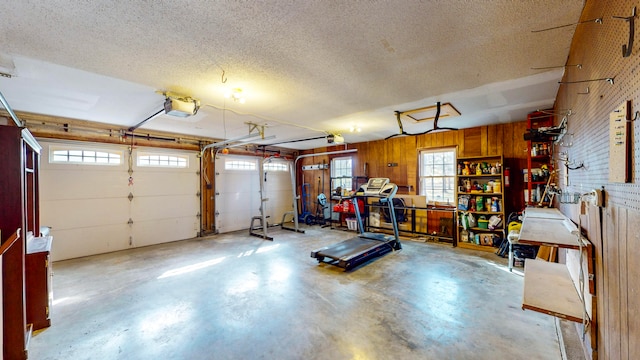 interior space with wooden walls, a textured ceiling, and a wealth of natural light