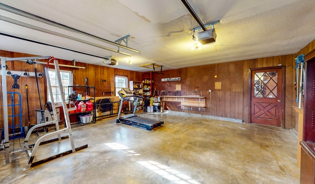 garage with a garage door opener and wooden walls