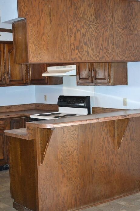 kitchen with ventilation hood, black range, and kitchen peninsula