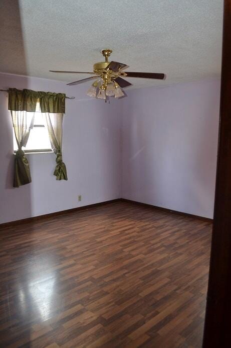 spare room featuring a textured ceiling, dark hardwood / wood-style floors, and ceiling fan