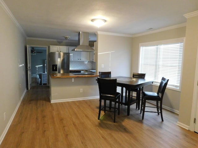 dining area featuring light hardwood / wood-style flooring and ornamental molding