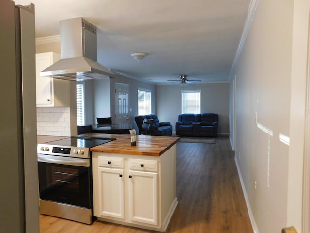 kitchen featuring white cabinetry, butcher block counters, exhaust hood, and electric range