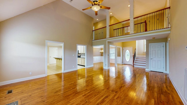 117 Windswept Dr NE, Cleveland, TN 37312 - unfurnished living room featuring ceiling fan, light wood-type flooring, stairs, and high vaulted ceiling