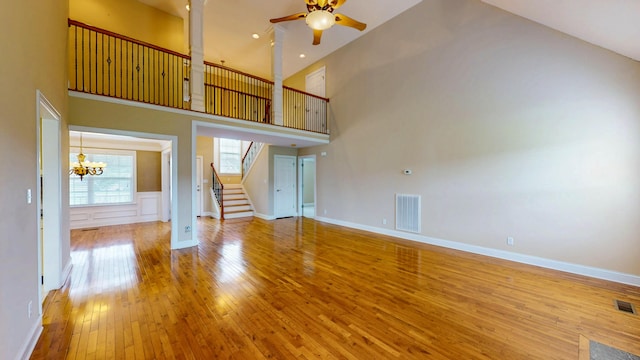 117 Windswept Dr NE, Cleveland, TN 37312 - unfurnished living room with hardwood / wood-style flooring, high vaulted ceiling, stairs, ceiling fan, and a chandelier