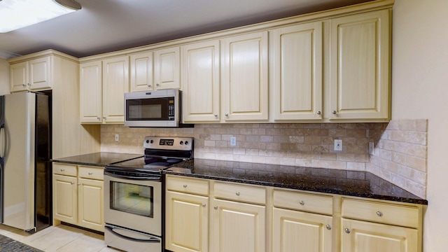 117 Windswept Dr NE, Cleveland, TN 37312 - kitchen featuring stainless steel appliances, cream cabinetry, tasteful backsplash, and dark stone counters