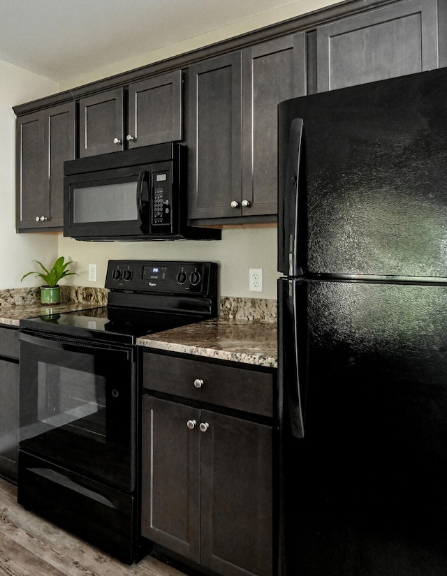 kitchen featuring light hardwood / wood-style flooring, black appliances, and dark brown cabinets