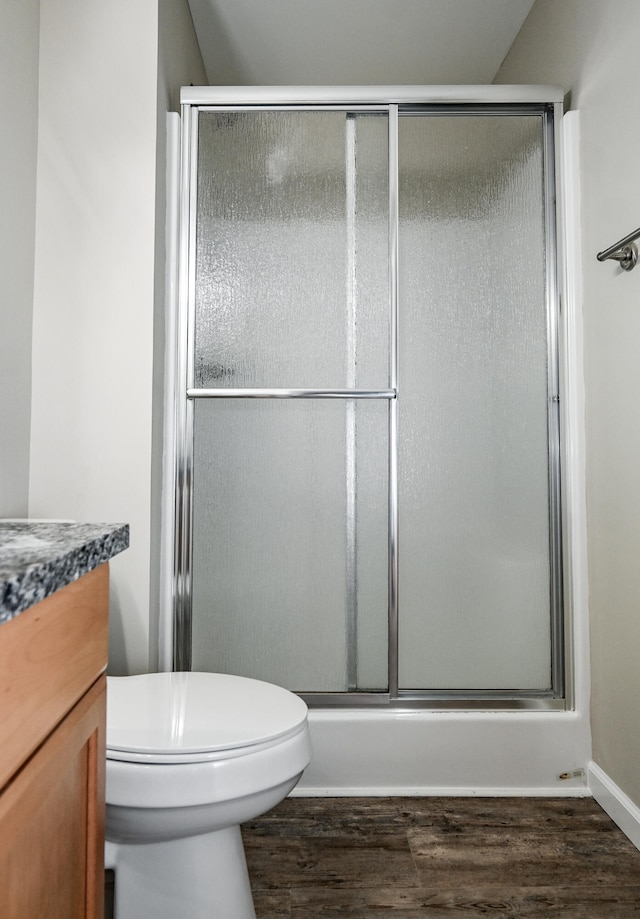 bathroom featuring an enclosed shower, vanity, hardwood / wood-style floors, toilet, and lofted ceiling