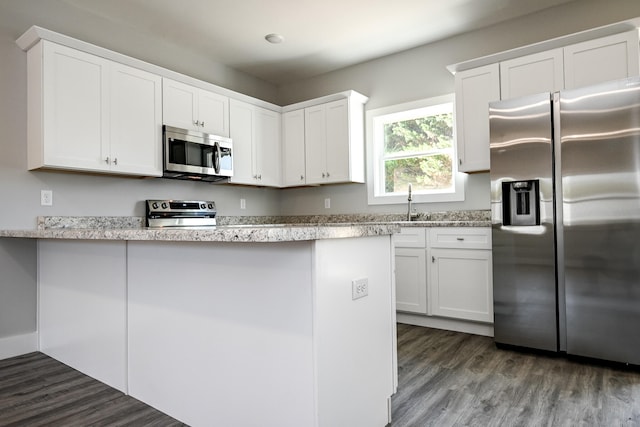 kitchen featuring hardwood / wood-style flooring, sink, white cabinets, and appliances with stainless steel finishes