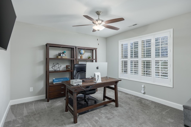 carpeted office space featuring ceiling fan