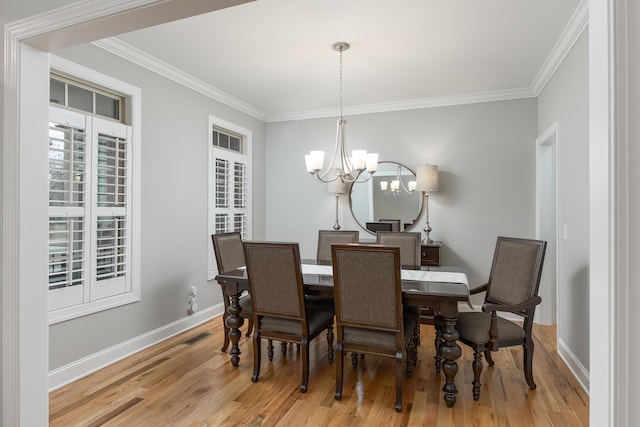 dining area with ornamental molding, light hardwood / wood-style floors, and a chandelier