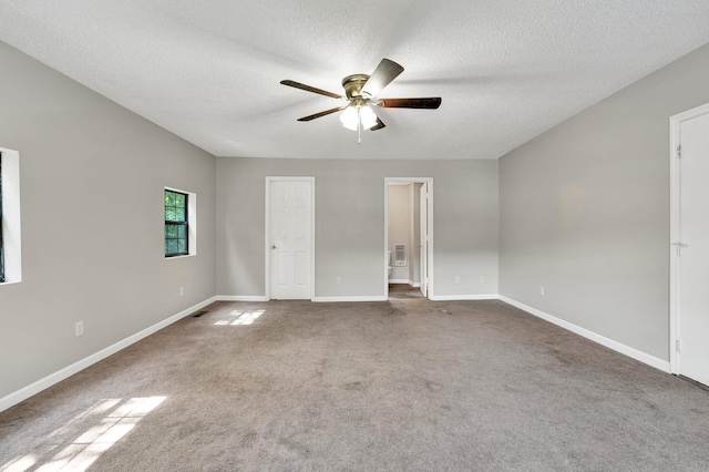 unfurnished bedroom featuring a textured ceiling, carpet floors, ensuite bathroom, and baseboards