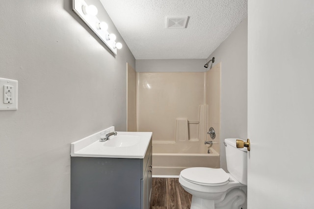 full bathroom featuring visible vents, toilet, wood finished floors, a textured ceiling, and vanity