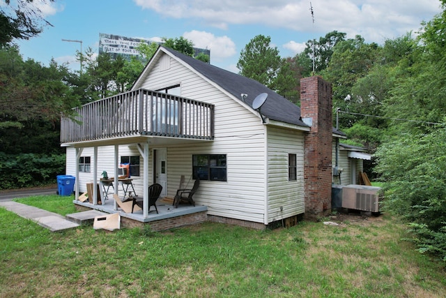 back of house featuring a patio, a lawn, a chimney, and central air condition unit