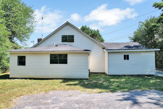 rear view of house featuring a yard