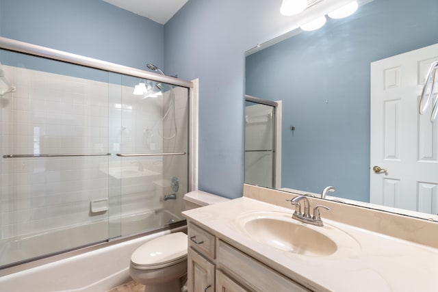 full bathroom featuring vanity, enclosed tub / shower combo, and toilet