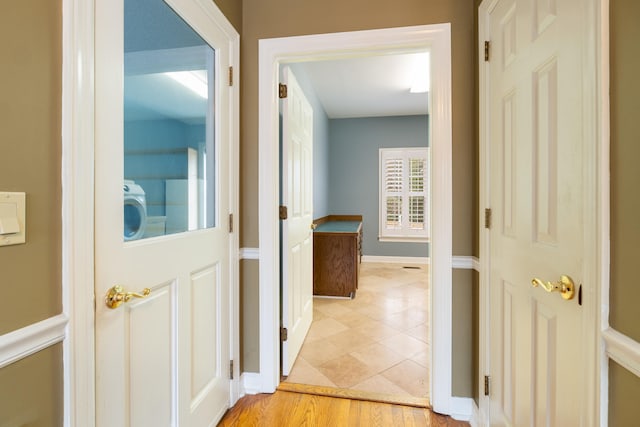 hall featuring washer / clothes dryer and light hardwood / wood-style flooring