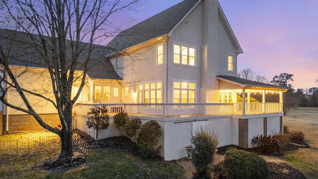 back house at dusk with a deck