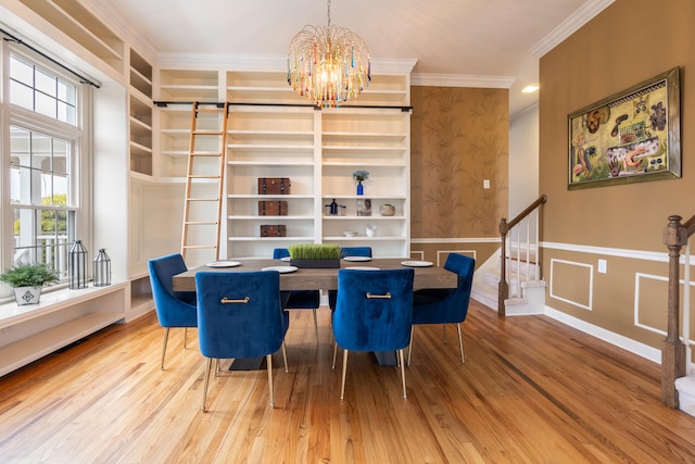 dining area featuring built in features, hardwood / wood-style flooring, an inviting chandelier, and ornamental molding